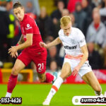 Pemain West Ham United Flynn Downes (kanan) berebut bola dengan pemain Liverpool Kostas Tsimikas