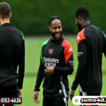 Pemain Arsenal, Raheem Sterling berbincang dengan rekan setimnya saat latihan