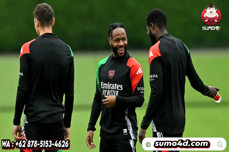 Pemain Arsenal, Raheem Sterling berbincang dengan rekan setimnya saat latihan