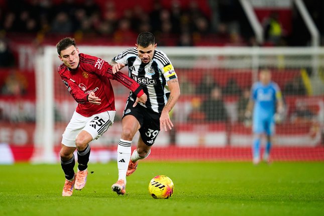 Pemain Manchester United, Manuel Ugarte (kiri), berebut bola dengan pemain Newcastle, Bruno Guimaraes, pada laga Premier League antara Manchester United vs Newcastle,